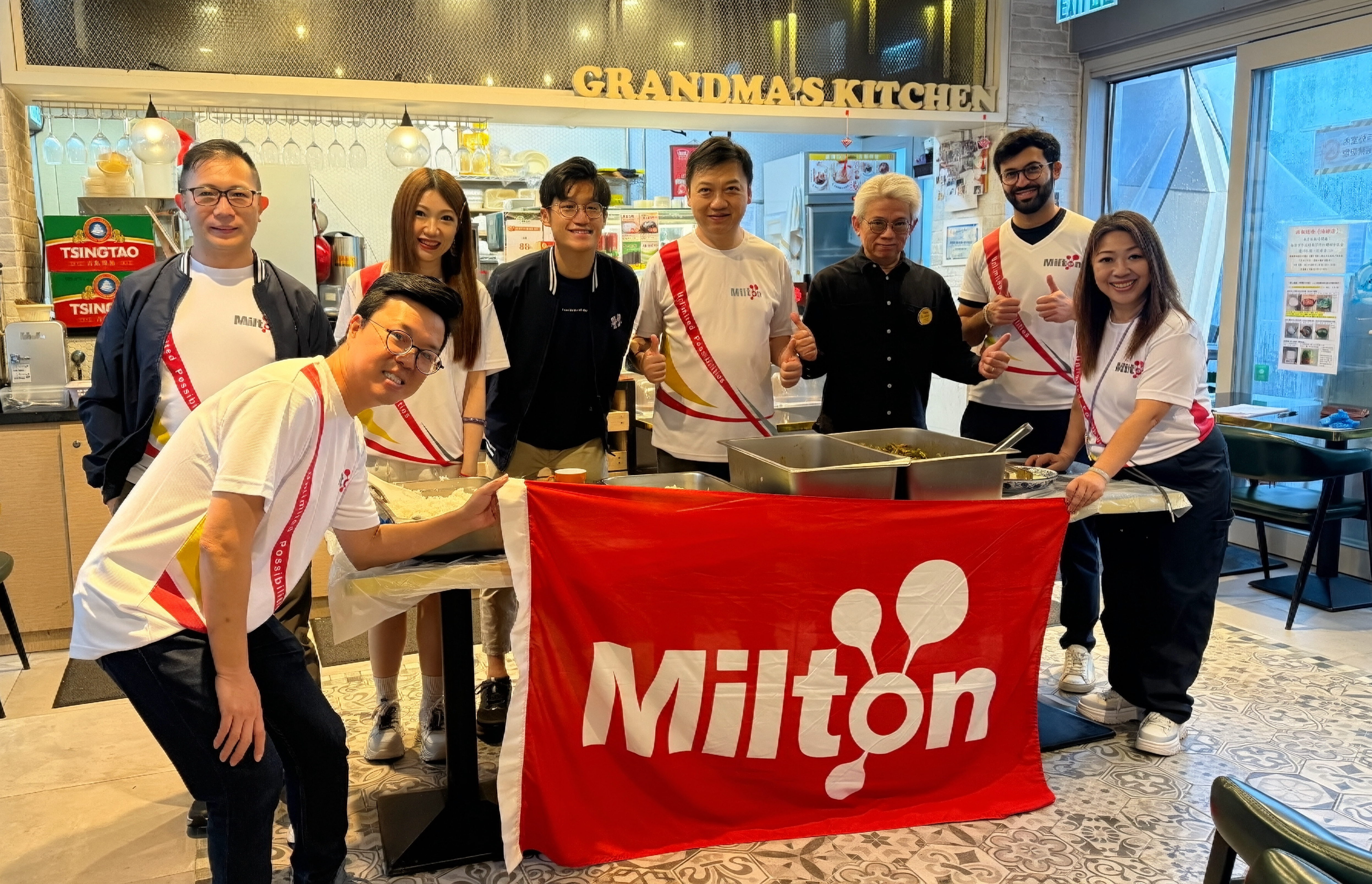 Milton volunteer team with Milton banner at Grandma's Kitchen, Gingko House